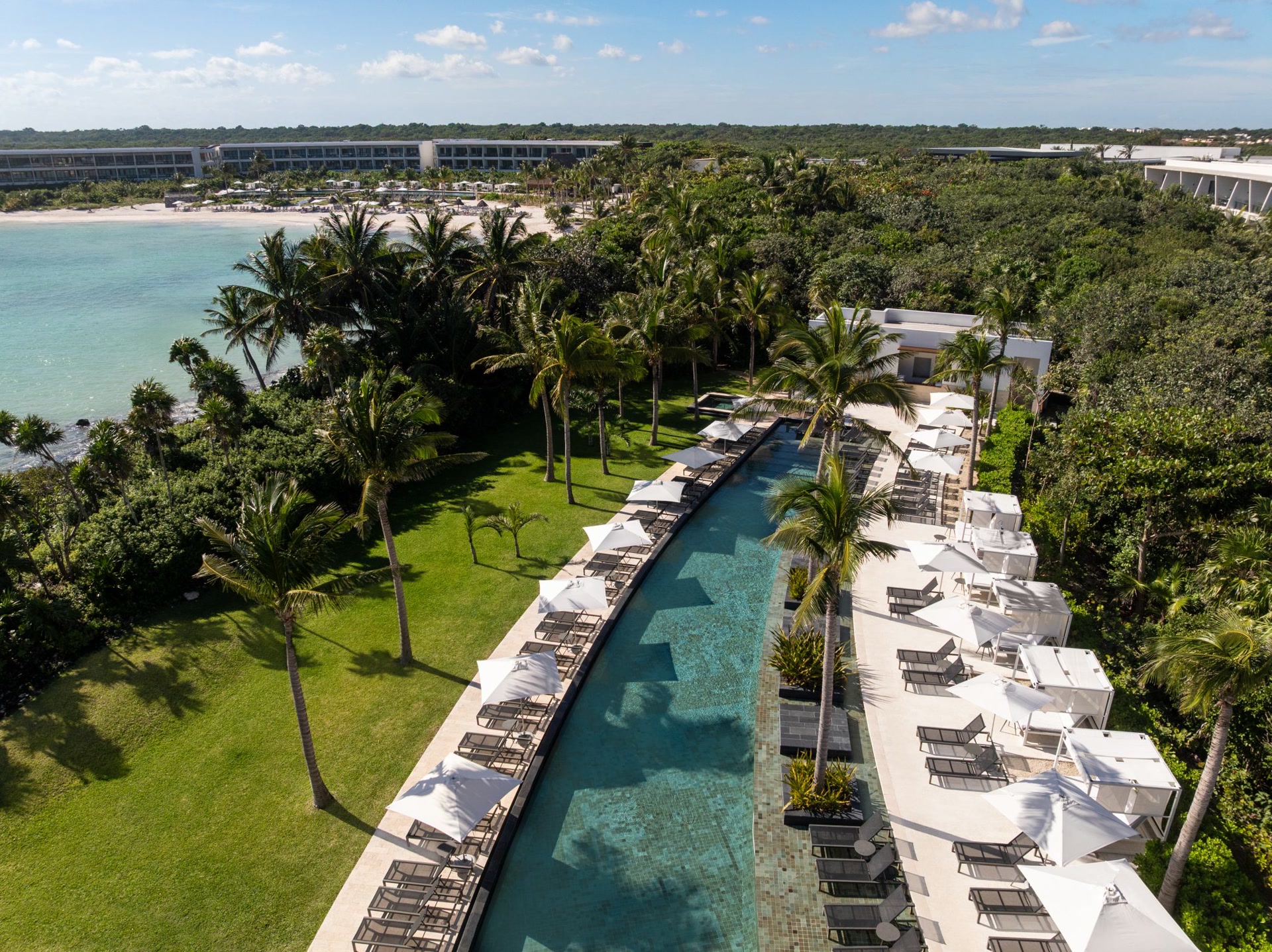 Aerial view of Conrad Tulum Riviera Maya, a luxury beachfront resort in Mexico ideal for incentive travel programs, executive retreats, and corporate meetings, showcasing pristine Caribbean waters, event-ready beachfront areas, and upscale poolside venues.