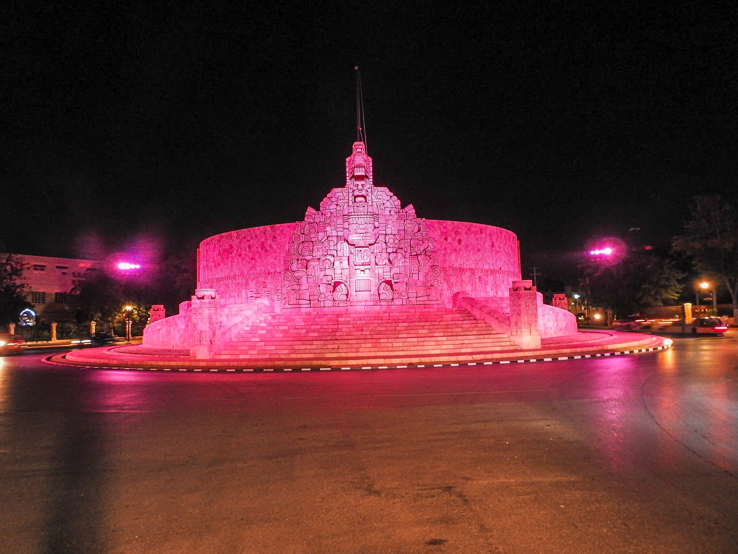 The Monumento a la Patria in Mérida lit up with vibrant pink lighting at night. This artistic monument is a spectacular sight for evening tours and a symbol of the city's blend of historic heritage and modern artistic flair, perfect for MICE and incentive travel.