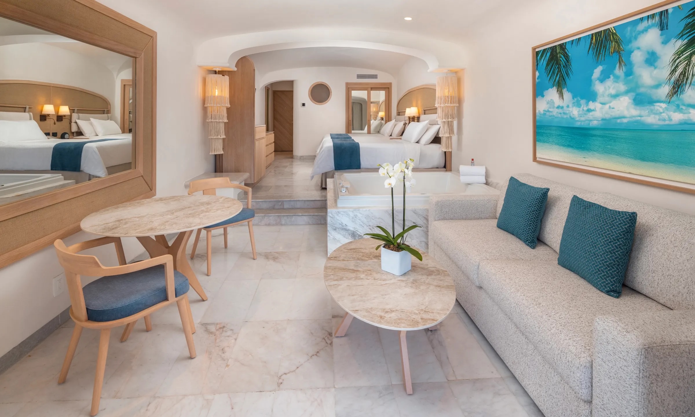 A brightly lit, modern restaurant interior at Cozumel Palace, featuring numerous tables set with white tablecloths and comfortable chairs, with an ocean view visible through large windows in the background. The expansive seating area is ideal for group dining, corporate breakfasts, or gala dinners, highlighting the resort's capacity to host various MICE F&B events for large conference or incentive groups.