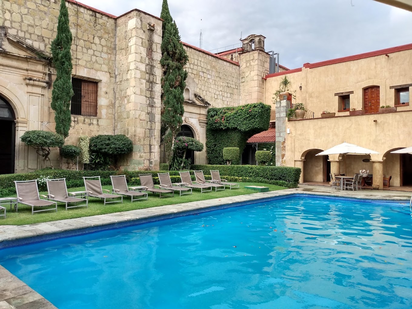 Historic courtyard pool at Hotel Quinta Real Oaxaca with lounge chairs, arched architecture, and garden views—ideal for MICE incentive travel, wellness breaks, and elegant outdoor receptions.