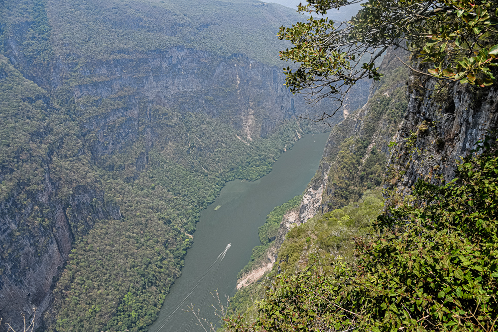 A stunning aerial view of the Cañón del Sumidero in Chiapas, Mexico, featuring a small boat on the Grijalva River. The image highlights a spectacular natural setting perfect for corporate incentive travel programs, exclusive events, and unique team-building activities.