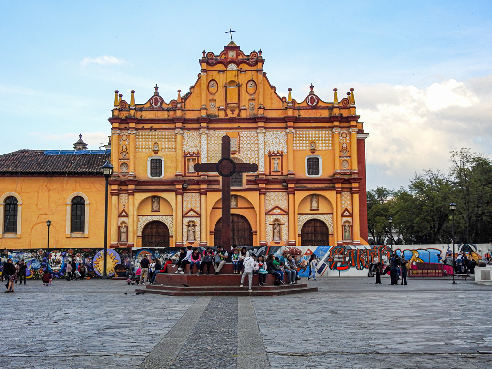A view of the historic Santo Domingo church in San Cristobal de las Casas, Chiapas, with a large cross in the foreground. A unique venue for MICE events.